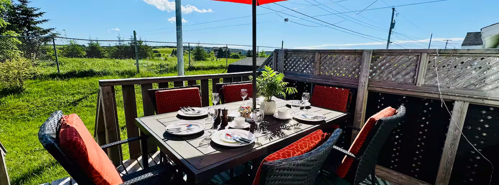 Sunny backyard patio in Airport Heights, set with outdoor dining furniture and lush green surroundings