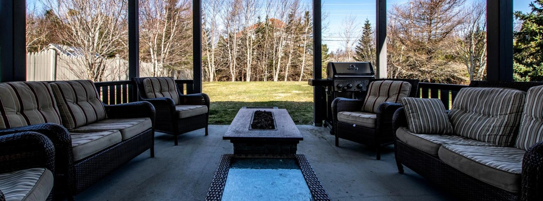 Cozy outdoor patio in King William's Estates, featuring comfortable seating, a barbecue area, and tranquil views of the private backyard
