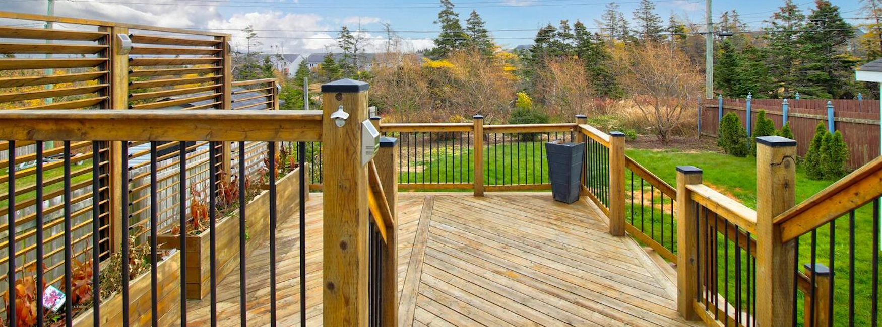 Spacious wooden deck overlooking a landscaped, fenced backyard in a Southlands home