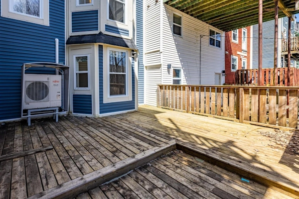 View of a backyard in downtown St. John's featuring a spacious wooden deck and blue exterior siding.