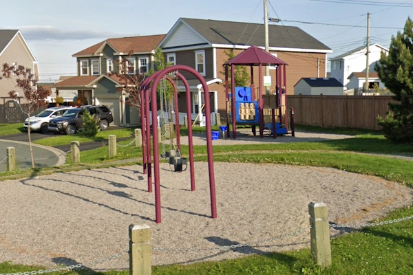 Jennmar Crescent Park playground in Southlands, showcasing swings, a play structure, and neighboring family homes.