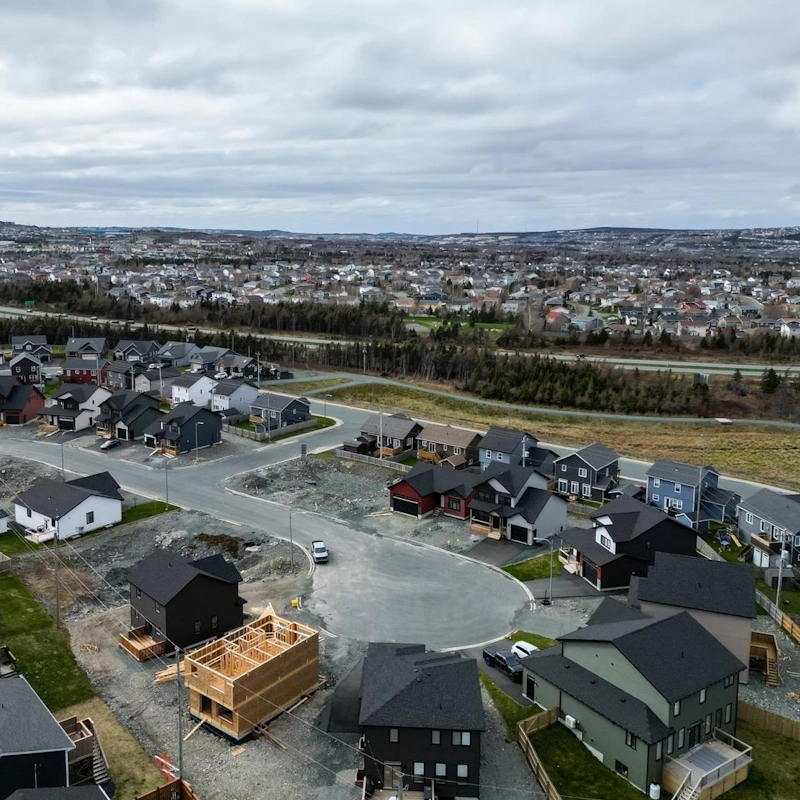 Aerial view of Southlands showing a cul-de-sac of modern homes, ongoing new construction, and the broader St. John’s skyline in the distance.